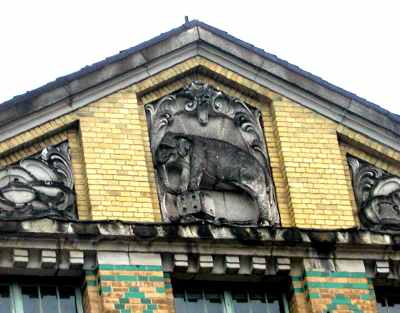 The bas-relief of the elephant stepping on the dice on the pediment of corner building of Aue Metal Goods Factory